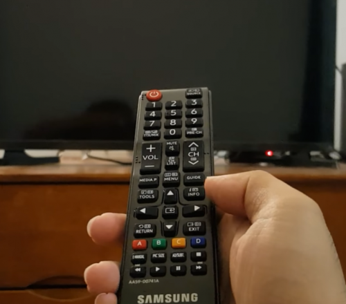 person holding Samsung remote