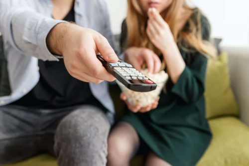 boy using a remote to control the TV