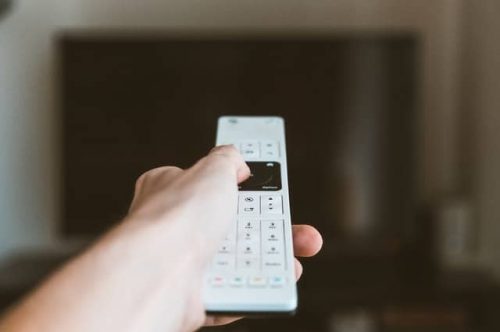 hand holding a white remote