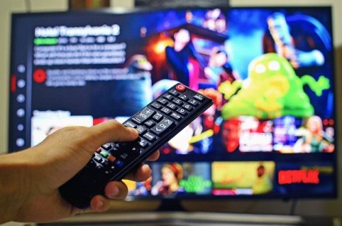 hand pointing remote at TV showing Netflix