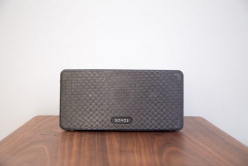 grey Sonos speaker on wooden surface