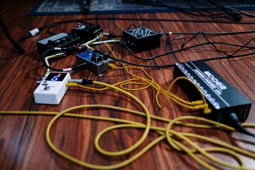 yellow XLR cable and audio interfaces on the floor