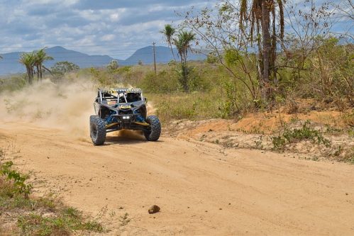 UTV running on a dirt road with dust behind it